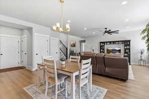 Dining space with hanging lights, light wood-style flooring, and a ceiling fan