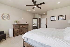 Bedroom with light colored carpet, ceiling fan, and recessed lighting