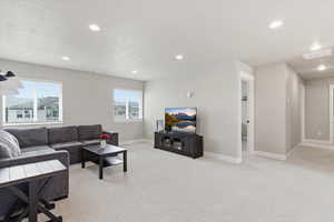 Living area featuring light carpet and recessed lighting