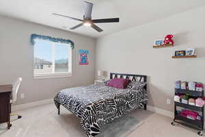 Bedroom with light colored carpet and a ceiling fan