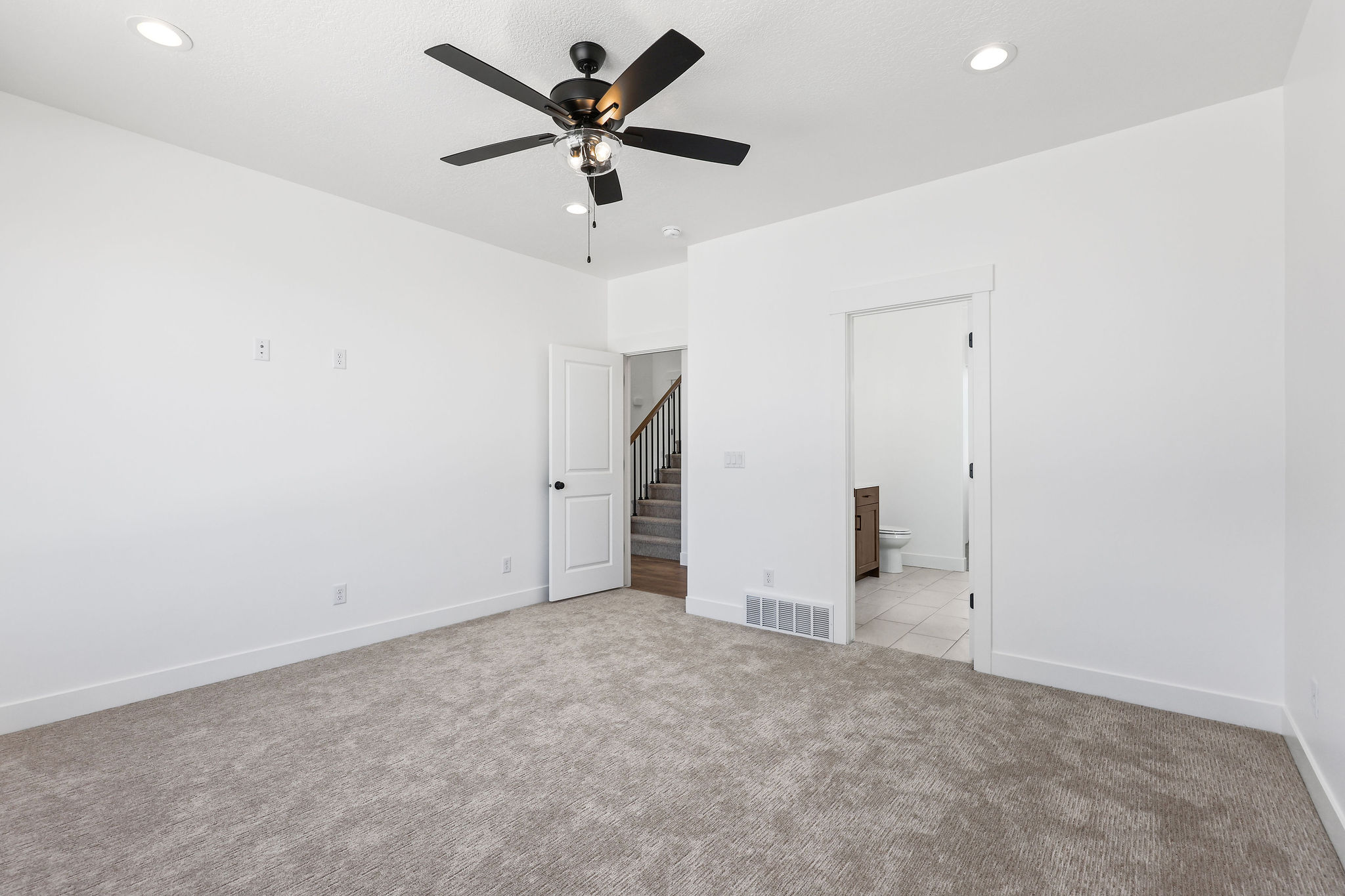 Spacious room featuring neutral carpeting, a ceiling fan with integrated lighting, recessed lighting, and crisp white walls