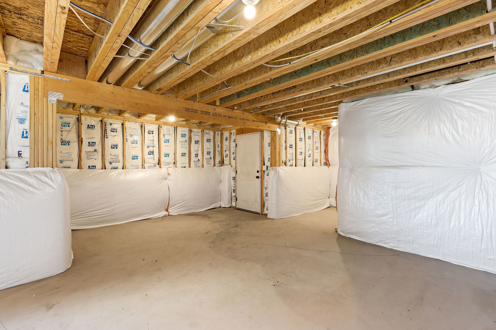 Unfinished basement with concrete flooring and exposed wood ceiling joists