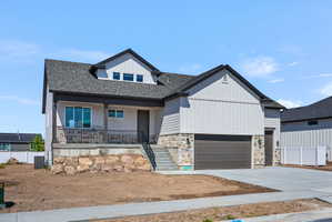 Modern two-story residence featuring light siding, stone accents, and a dark shingle roof