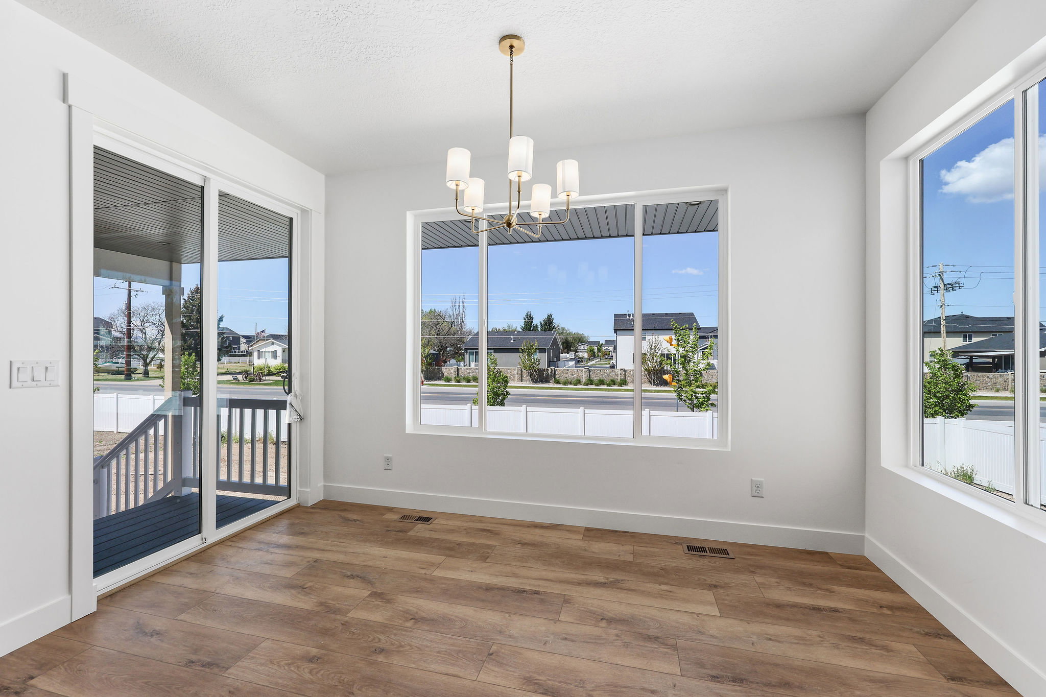 Bright interior space featuring wood-finish flooring and a contemporary chandelier