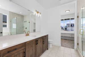 Bathroom featuring a wide vanity with a light-toned countertop, a full-width mirror, and a rectangular under-mount sink
