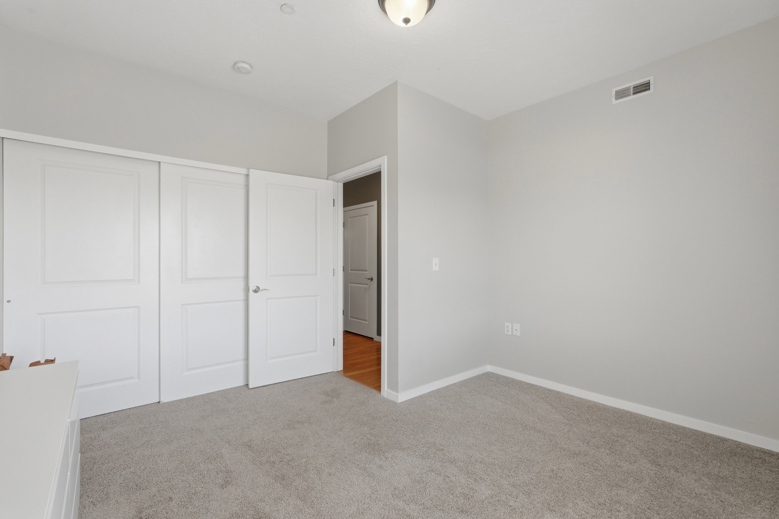 Unfurnished bedroom with light carpet and a closet