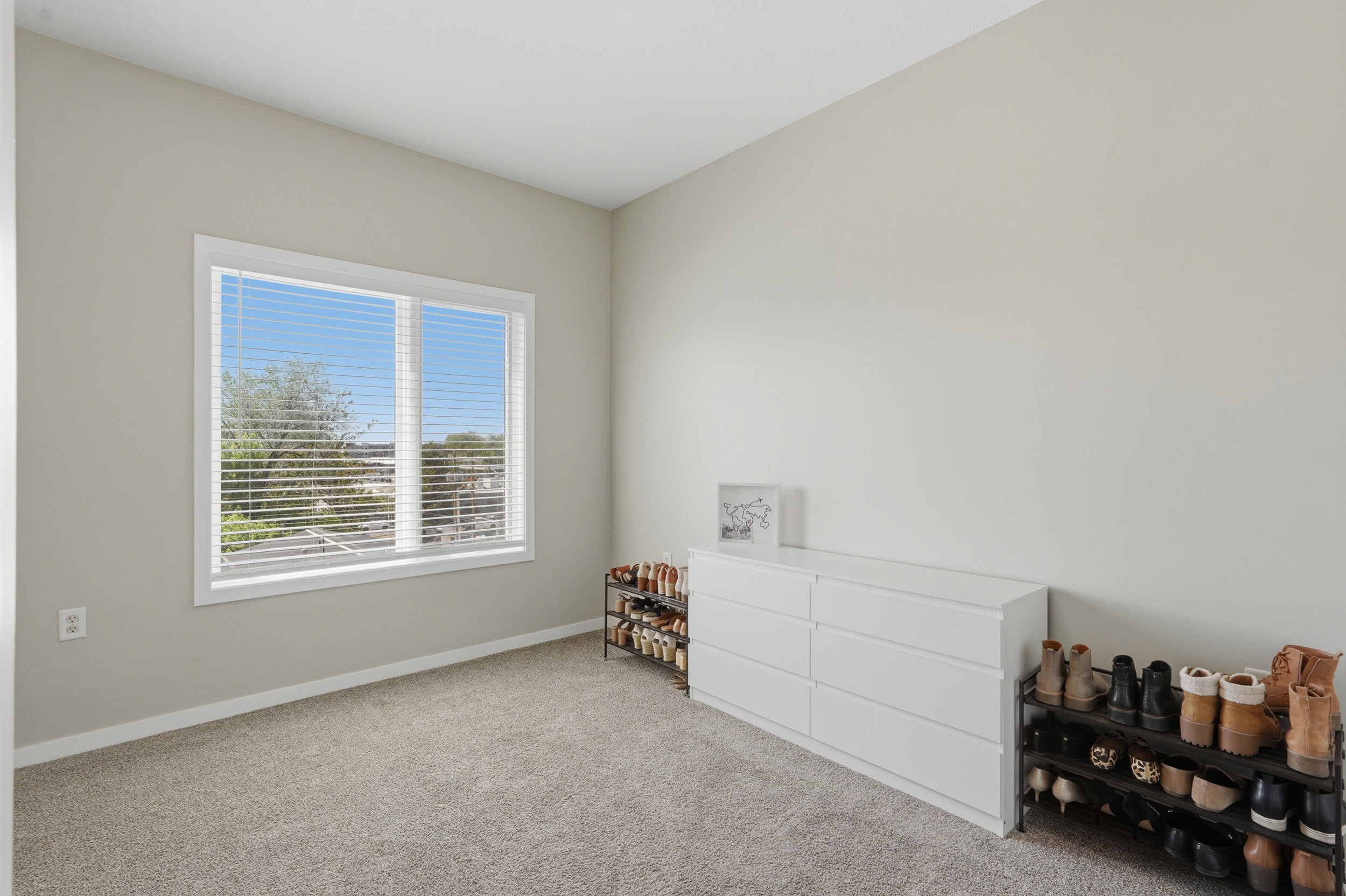 Bedroom featuring light colored carpet and baseboards