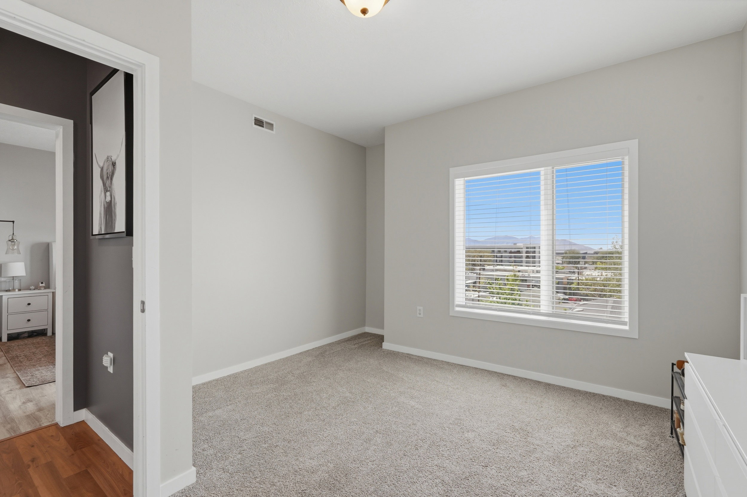 Unfurnished bedroom with baseboards and light carpet