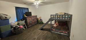 Bedroom with dark wood finished floors, ceiling fan, and a textured ceiling