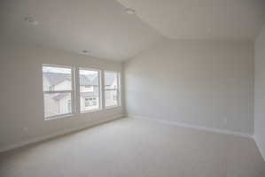 Spacious room featuring three large windows, recessed ceiling lighting, light-colored carpeting, and painted walls with white trim