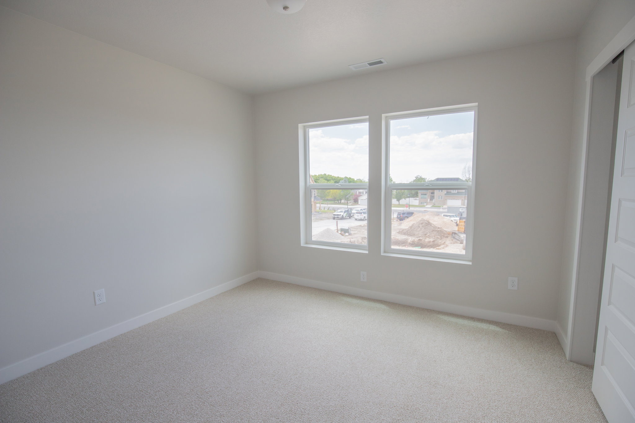 Room featuring light-toned carpeting, neutral wall paint, and white trim