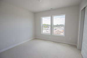 Room featuring light-toned carpeting, neutral wall paint, and white trim