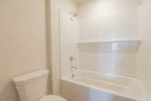 White subway tile shower surround with integrated shelving and chrome fixtures