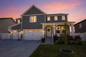Modern farmhouse style home with a gate, board and batten siding, concrete driveway, a porch, and a garage