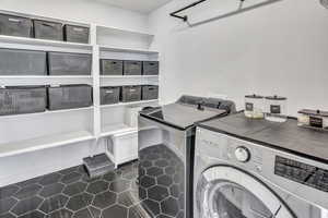 Laundry room featuring dark tile patterned floors and washer and dryer