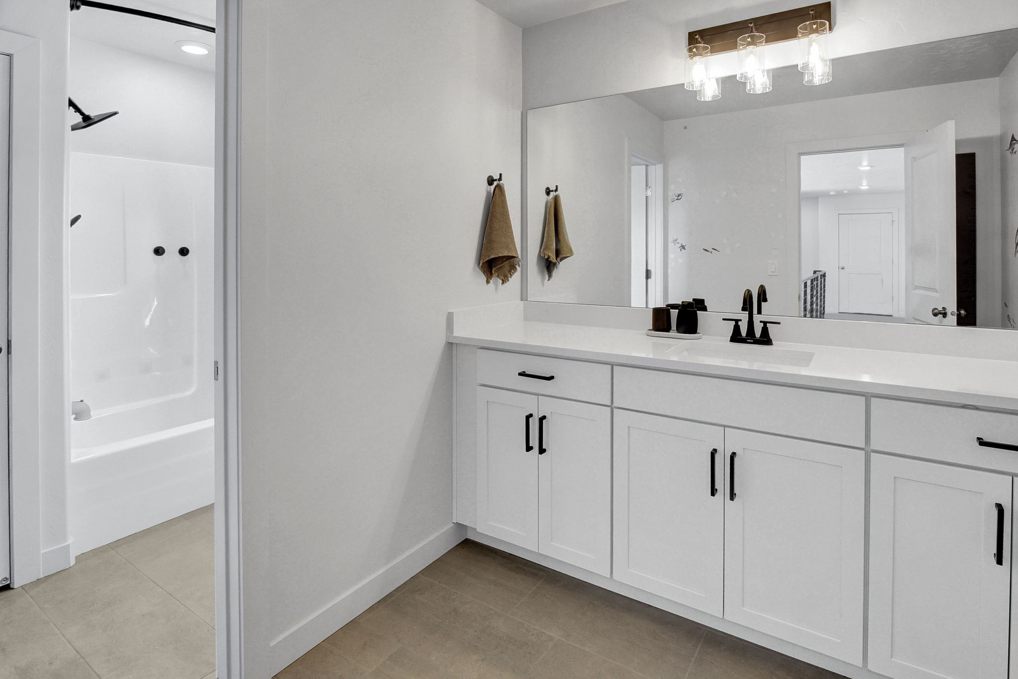 Bathroom with vanity, light tile patterned flooring, and shower / washtub combination