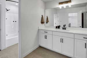 Bathroom with vanity, light tile patterned flooring, and shower / washtub combination