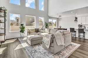 Living room with dark wood finished floors, a high ceiling, and recessed lighting