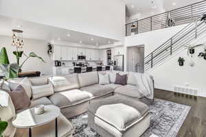 Living area featuring dark wood finished floors, recessed lighting, and a high ceiling