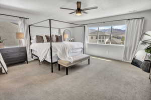 Bedroom featuring a mountain view, light carpet, and ceiling fan