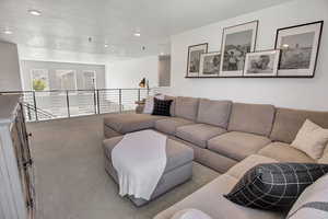 Carpeted living area with recessed lighting