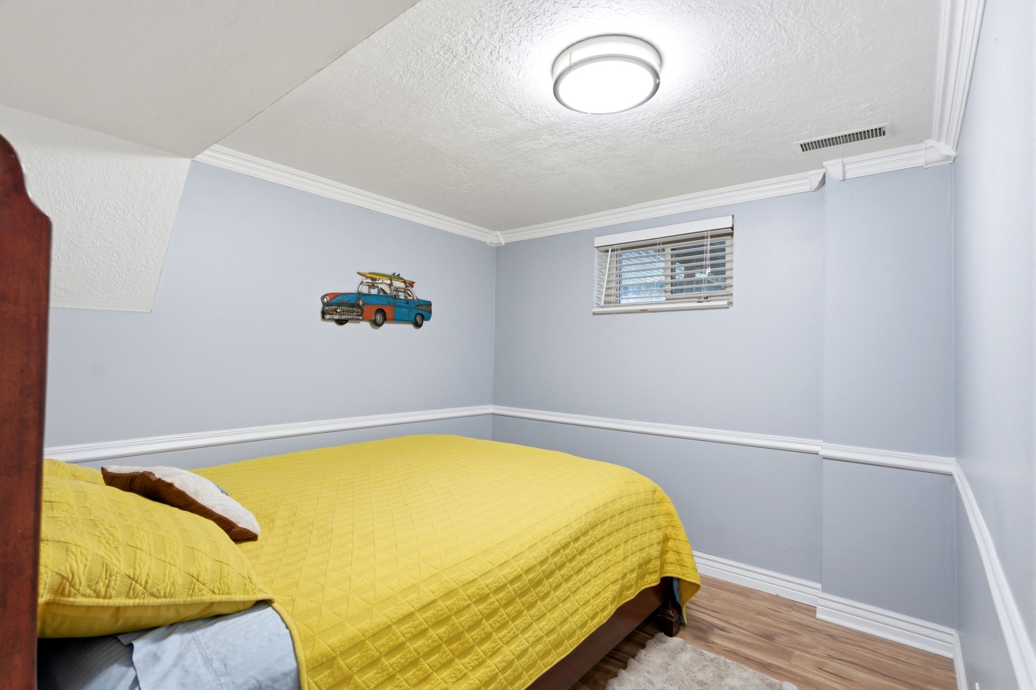 Bedroom featuring light wood-style flooring, a textured ceiling, and ornamental molding