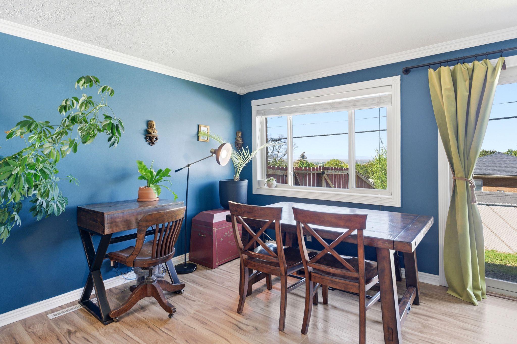 Dining space featuring light wood finished floors, crown molding, and a textured ceiling