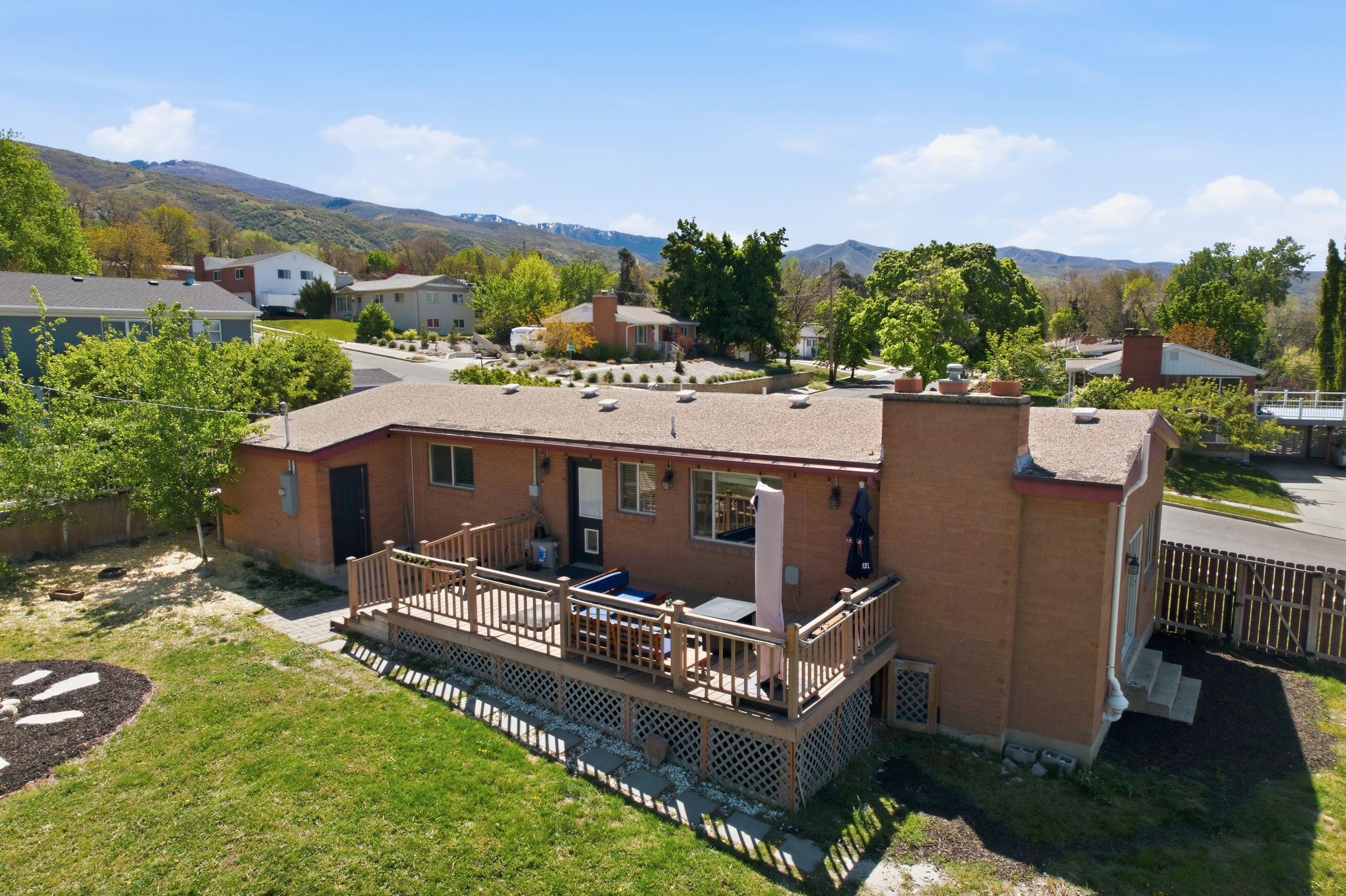 Back of property with a deck with mountain view and a residential view