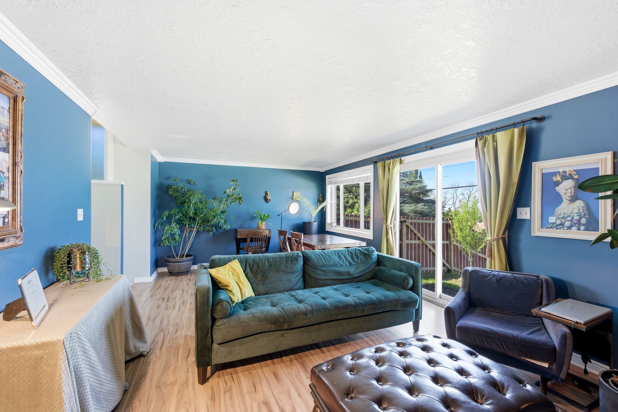 Living room featuring wood finished floors, a textured ceiling, and crown molding