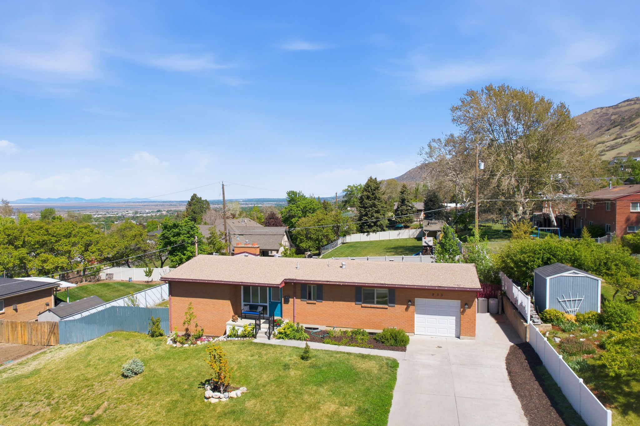 View of front of property with concrete driveway, a mountain view, brick siding, and an attached garage