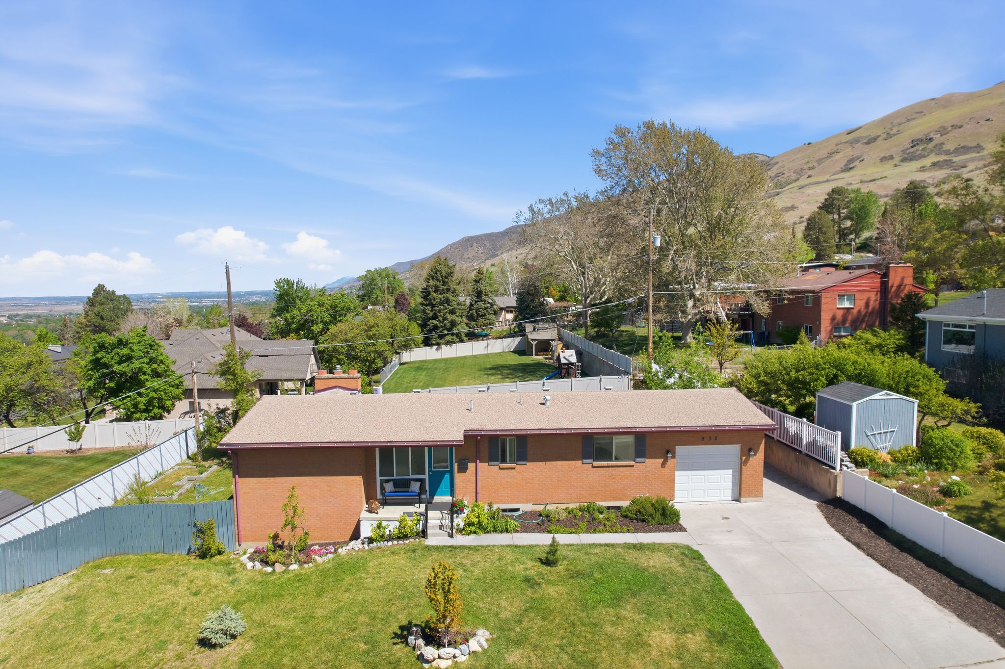 View of front of property with brick siding, driveway, a mountain view, a residential view, and an attached garage