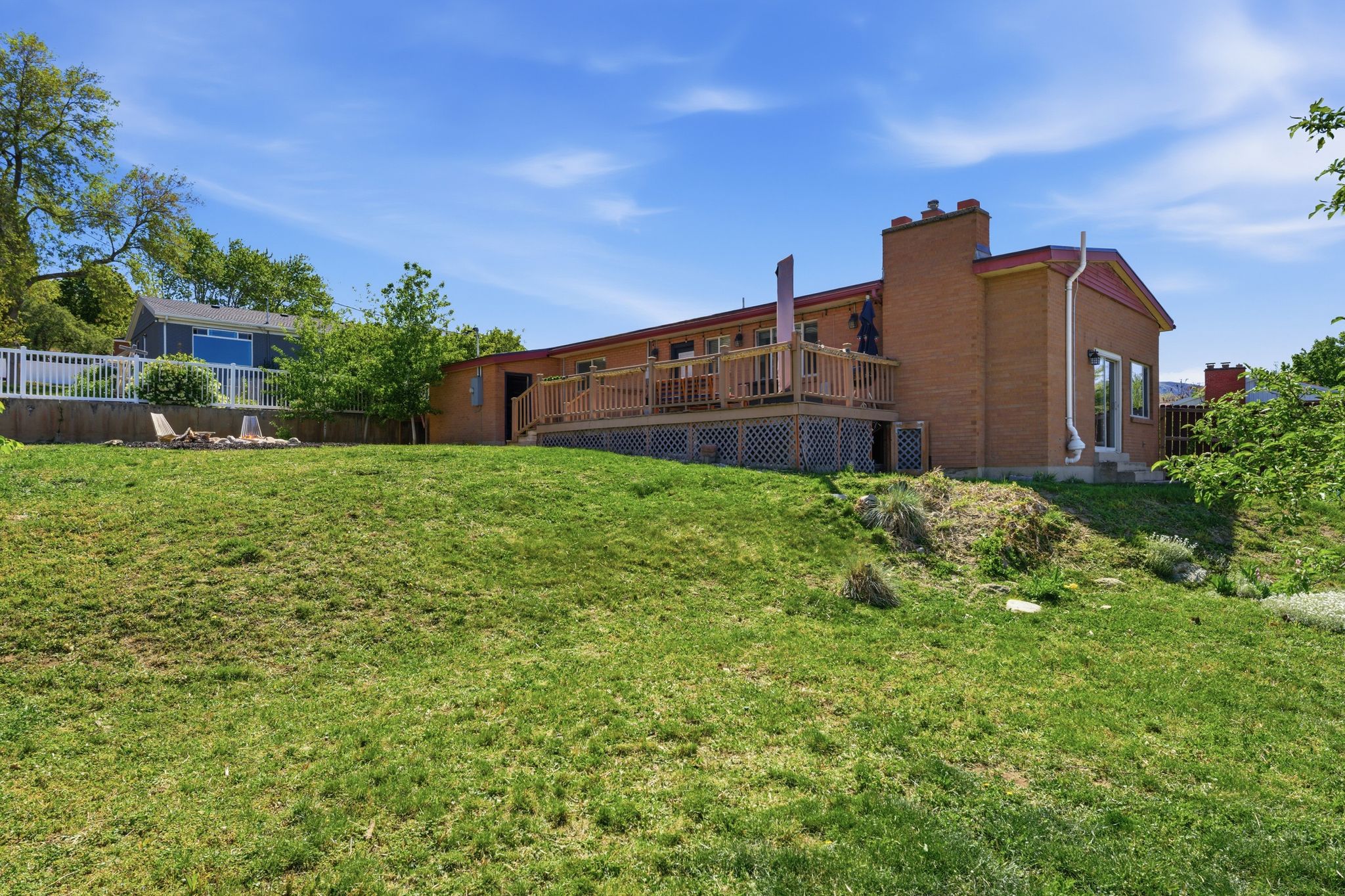 Back of house featuring a deck and brick siding