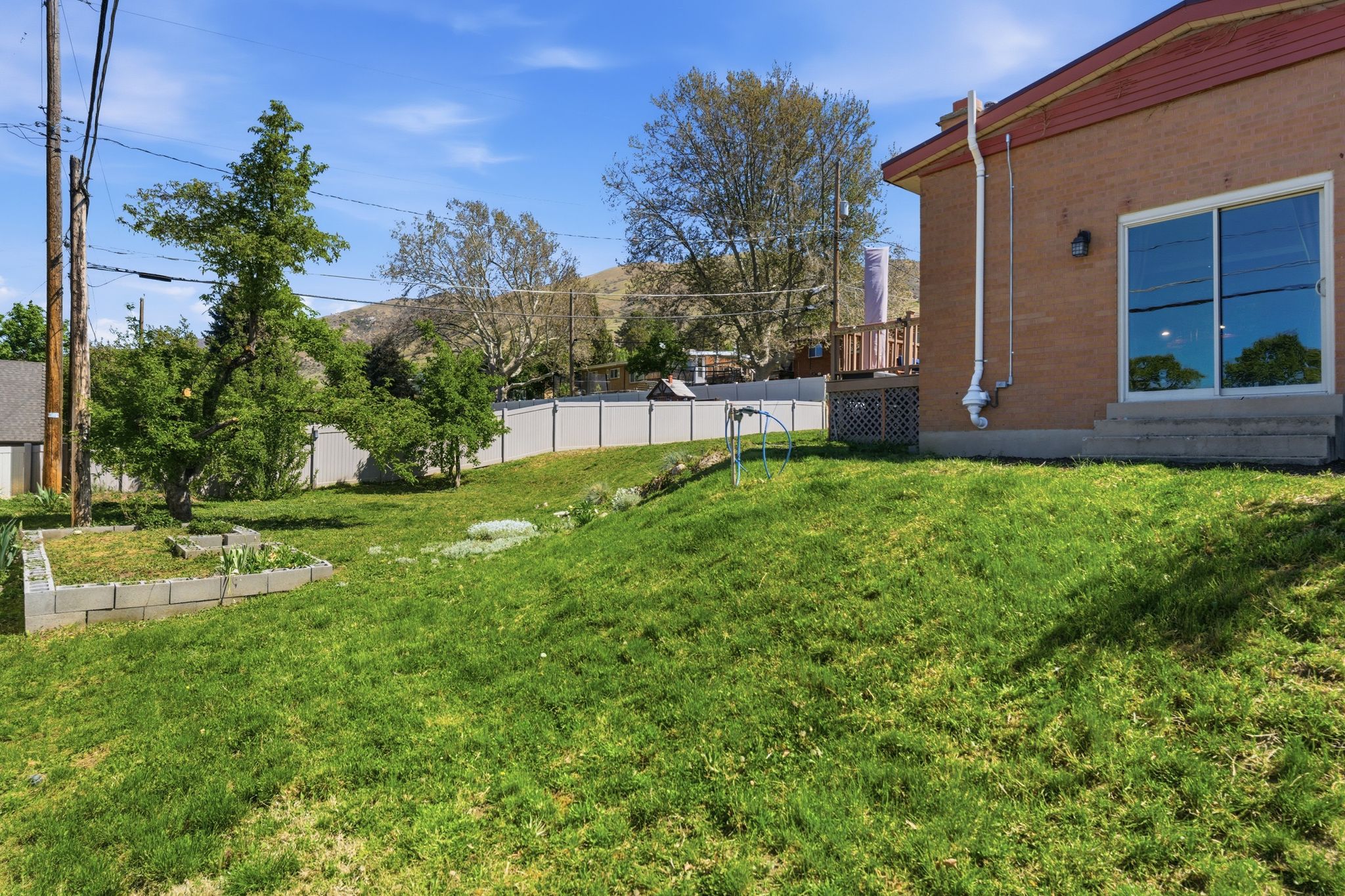 Fenced yard featuring a wooden deck and a vegetable garden
