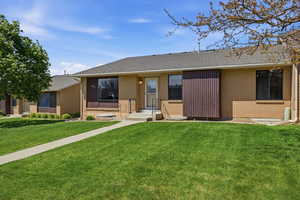 Ranch-style house with a front yard, brick siding, and roof with shingles