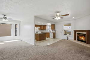 Unfurnished living room featuring a ceiling fan, light carpet, a tiled fireplace, recessed lighting, and a textured ceiling