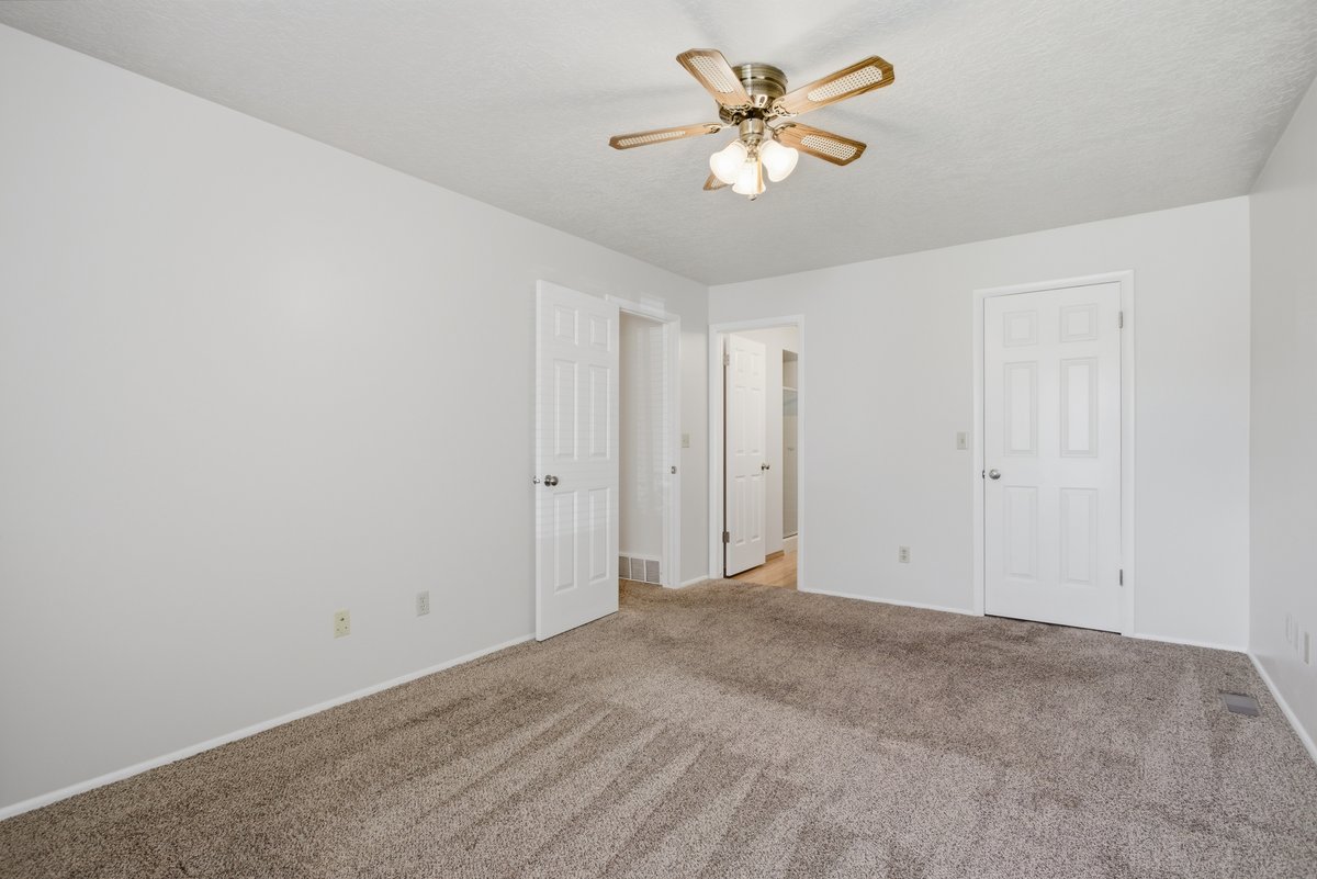 Unfurnished bedroom featuring light colored carpet and ceiling fan