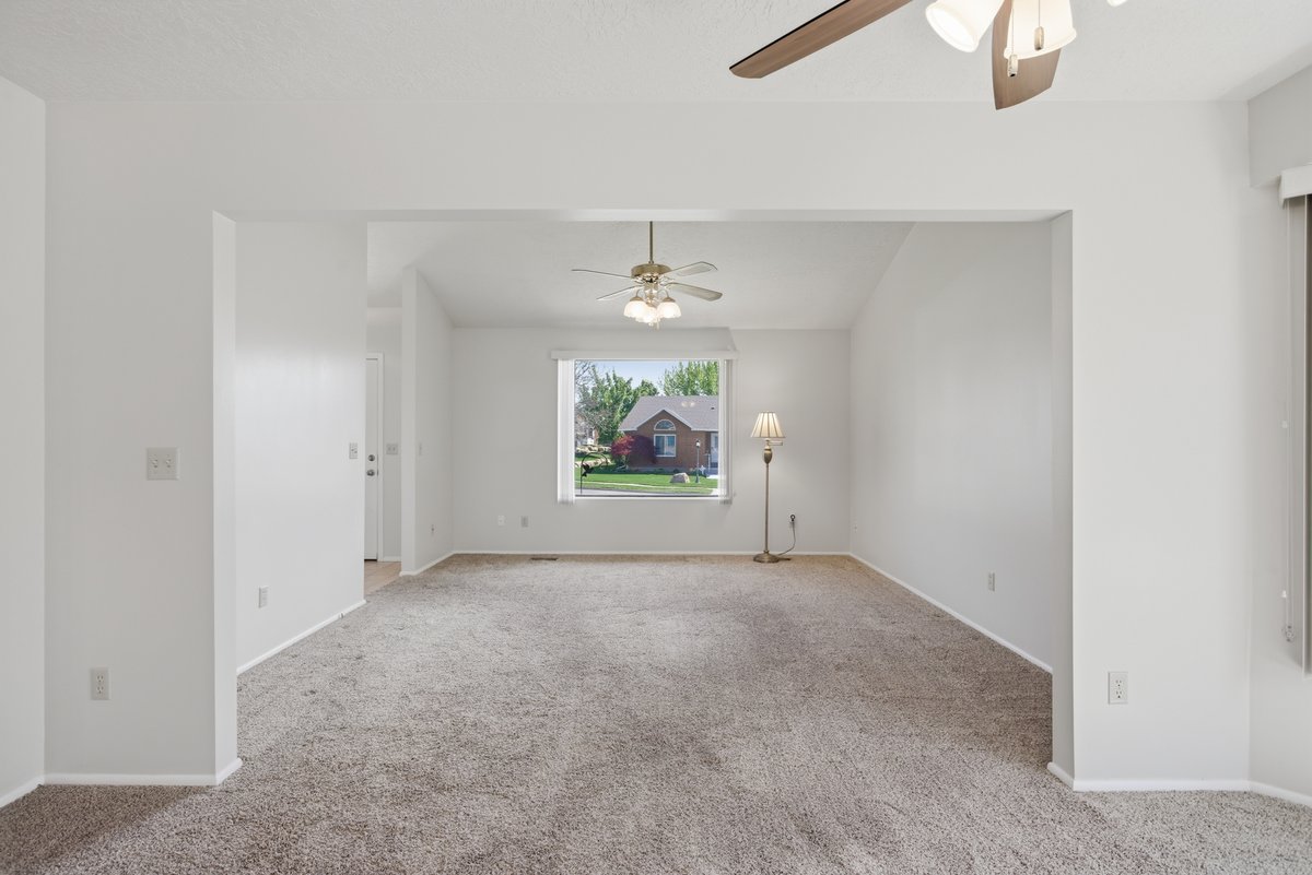 Unfurnished room with a ceiling fan and light colored carpet