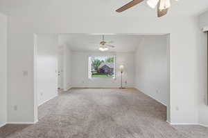Unfurnished room with a ceiling fan and light colored carpet