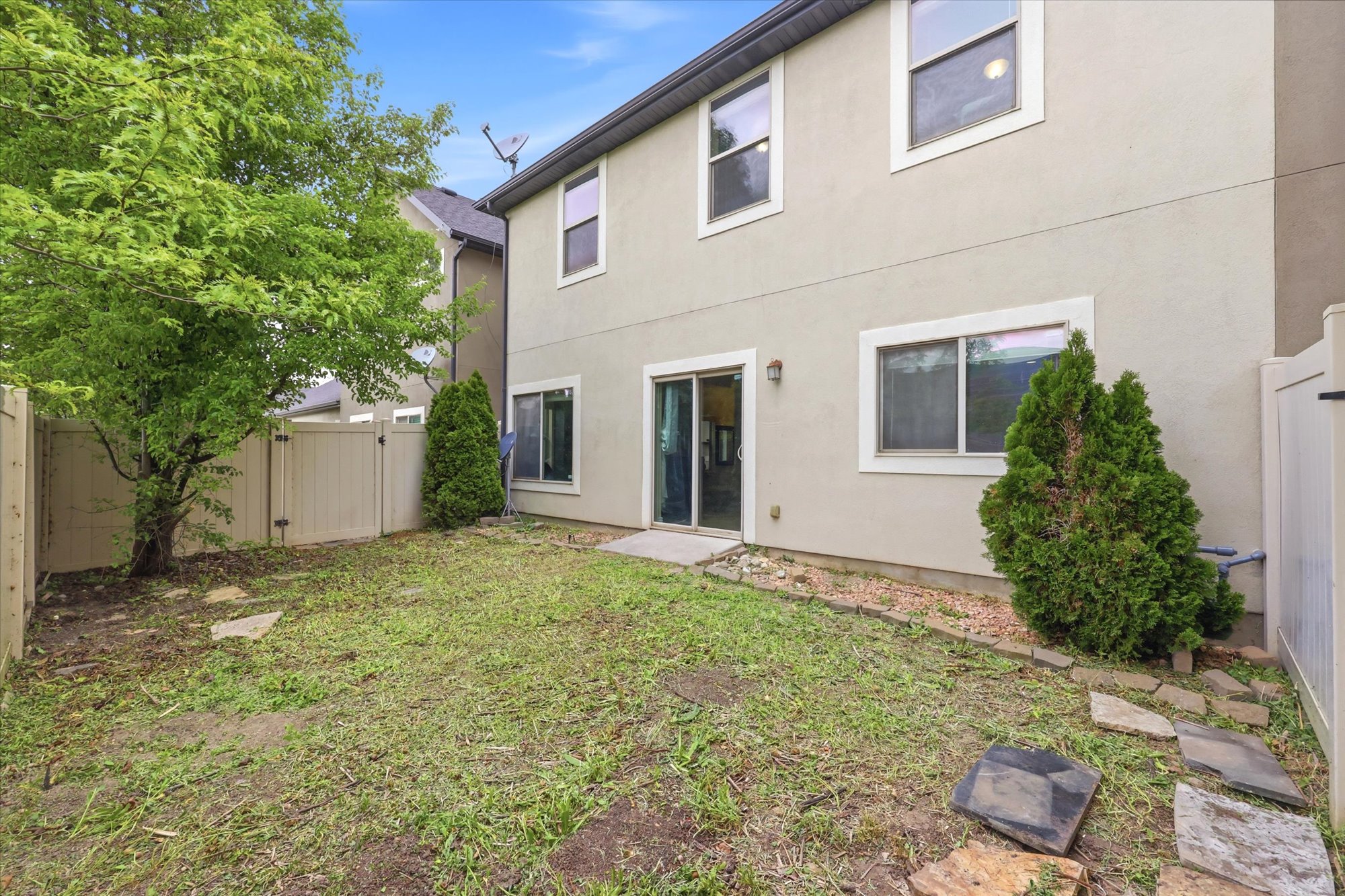 Back of house with a fenced backyard, stucco siding, and a gate