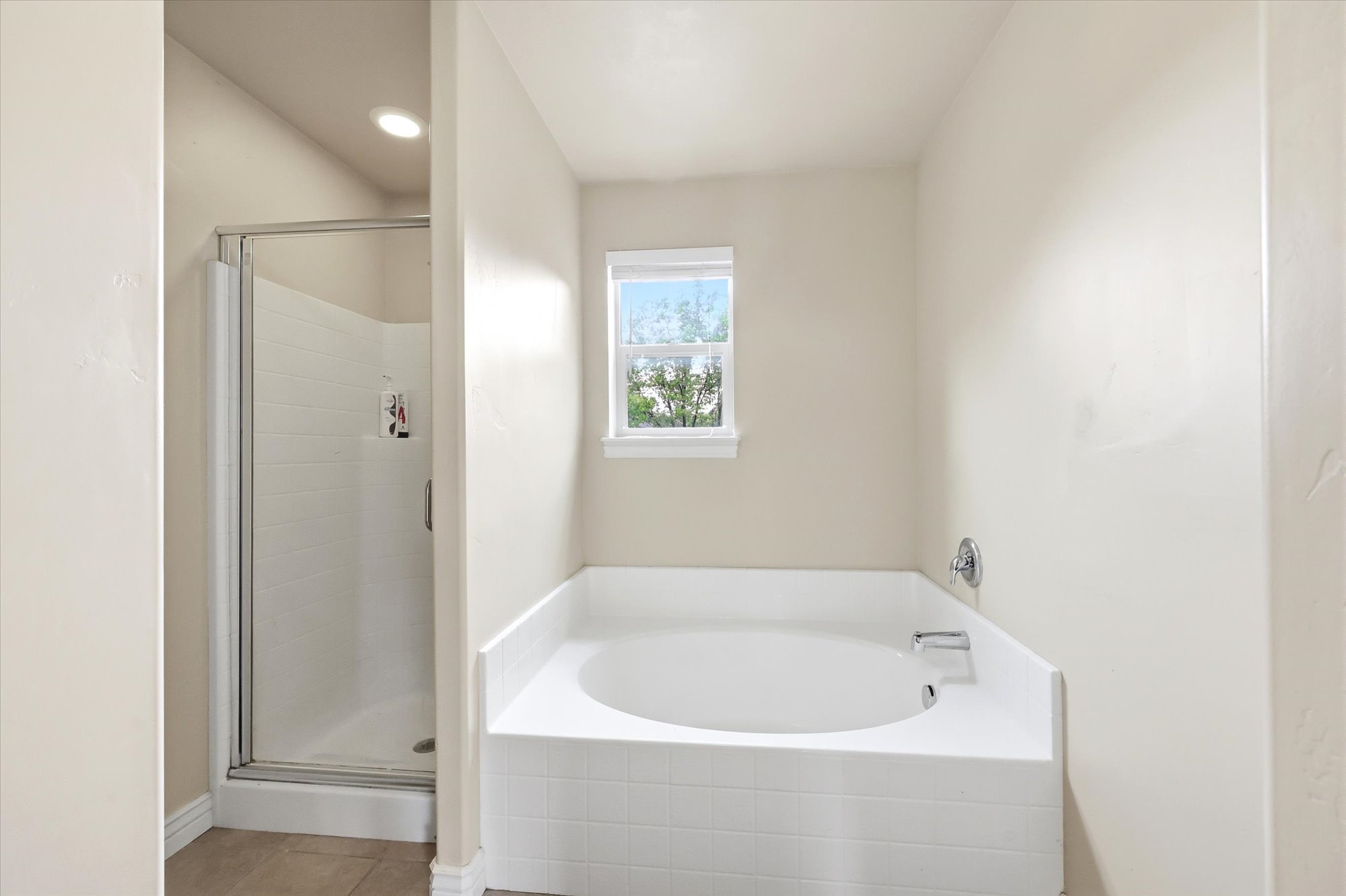 Bathroom with a shower stall, a garden tub, light tile patterned flooring, and recessed lighting