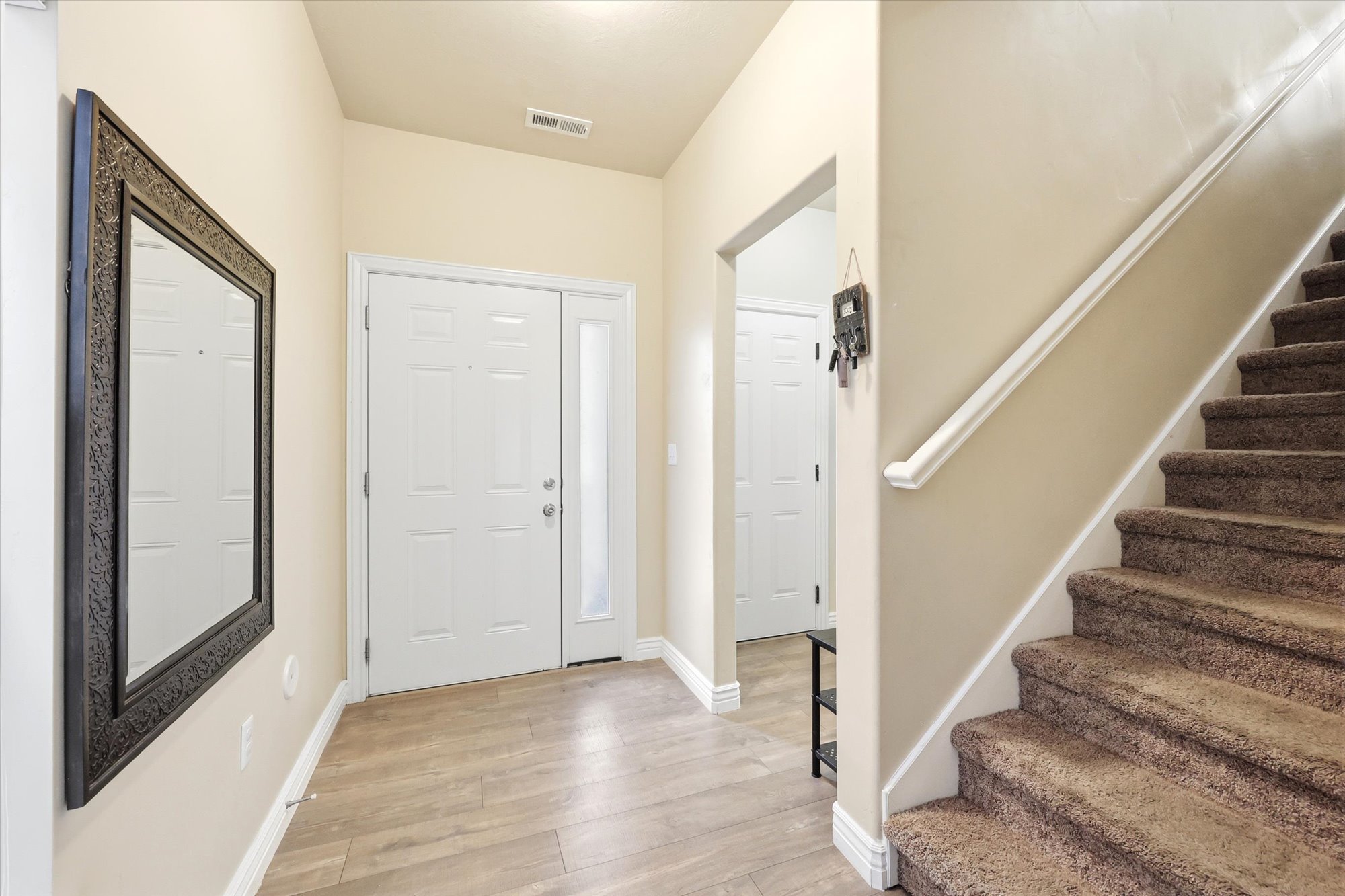 Foyer with stairs and light wood-style flooring