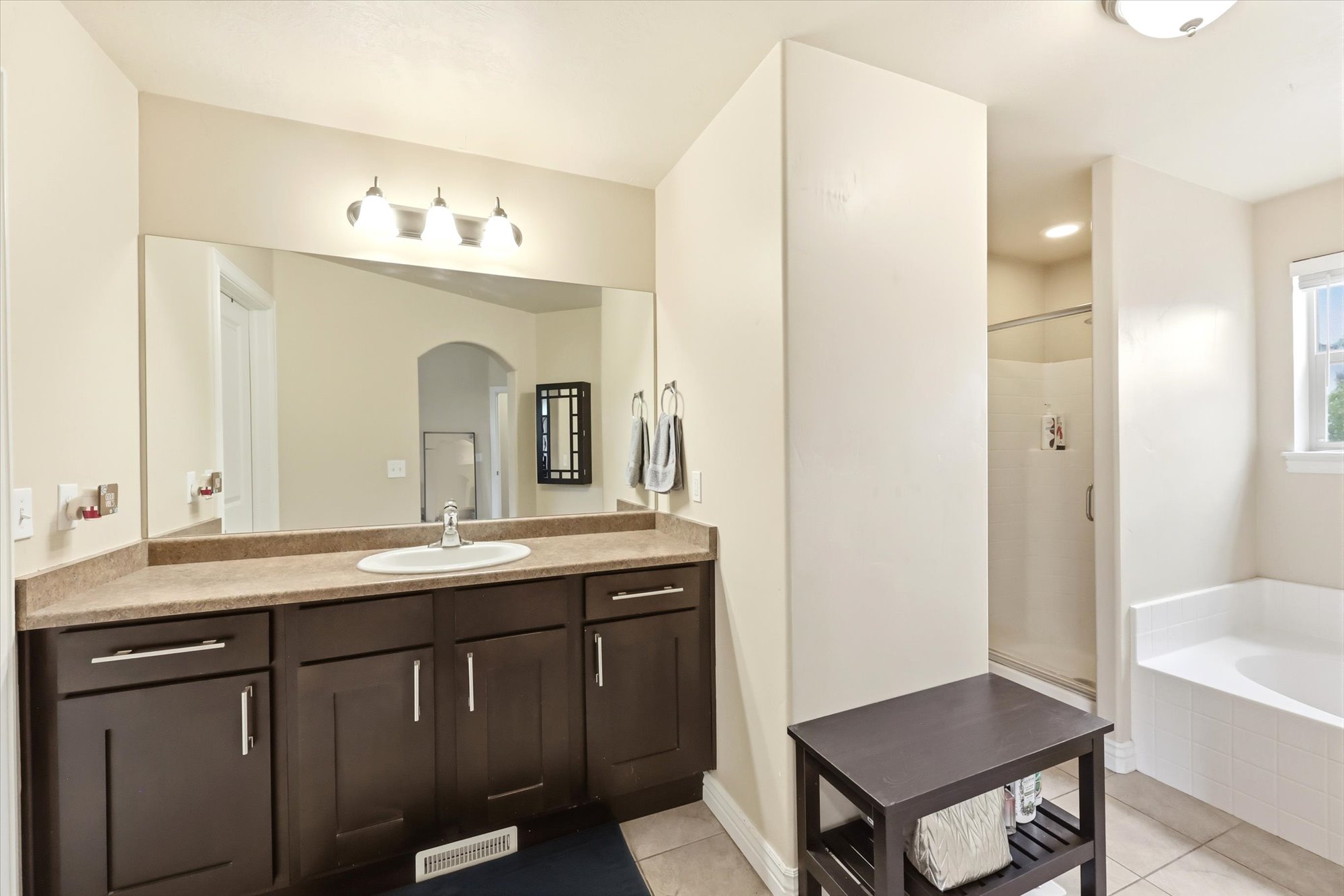 Full Primary bathroom with vanity, a shower stall, light tile patterned floors, and a bath