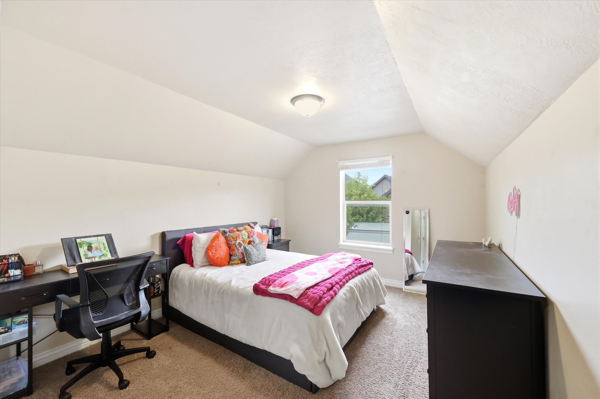 Bedroom with an office area and light colored carpet