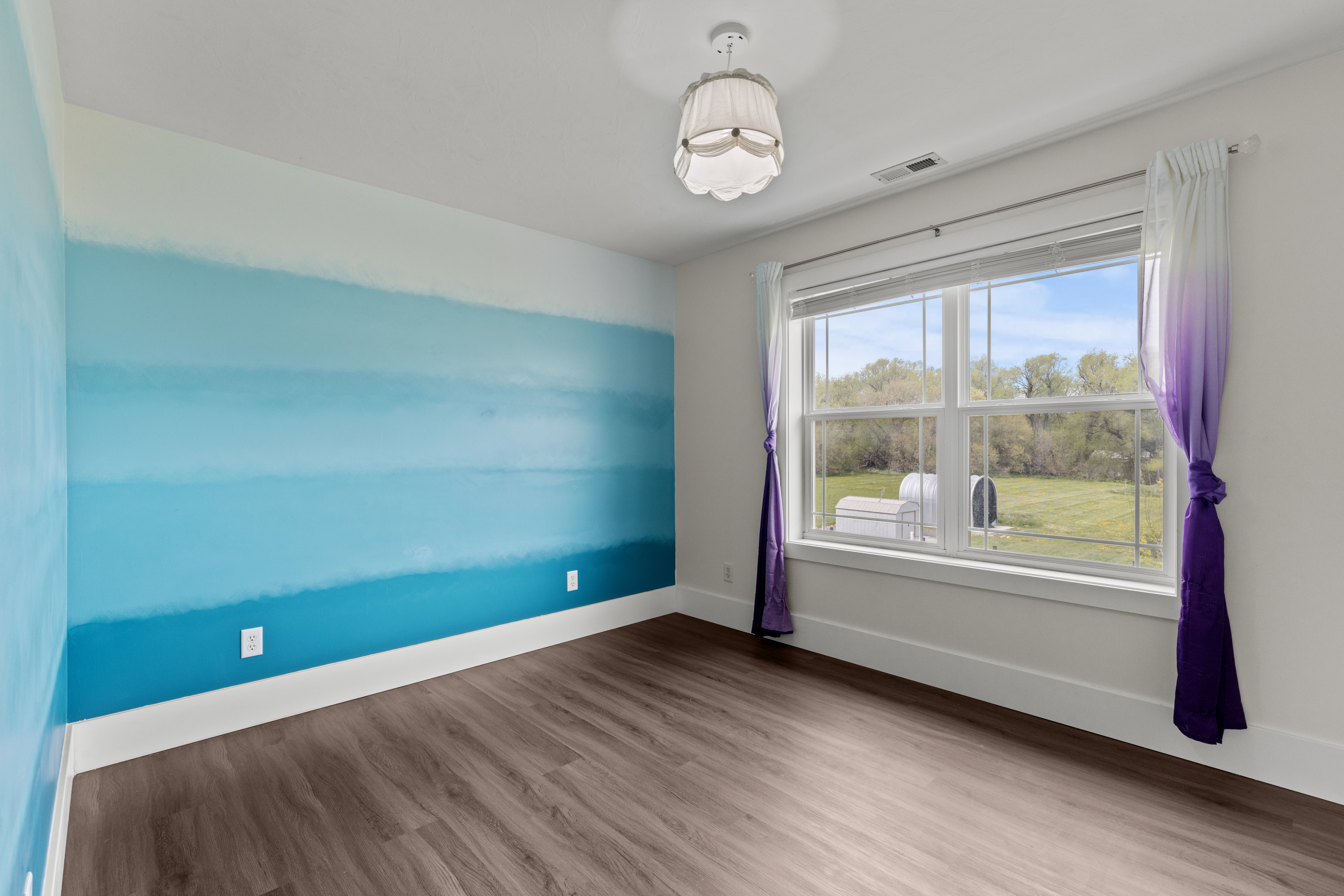 Spare room with dark wood finished floors and baseboards