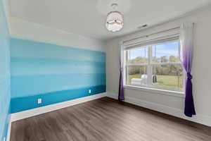 Spare room with dark wood finished floors and baseboards