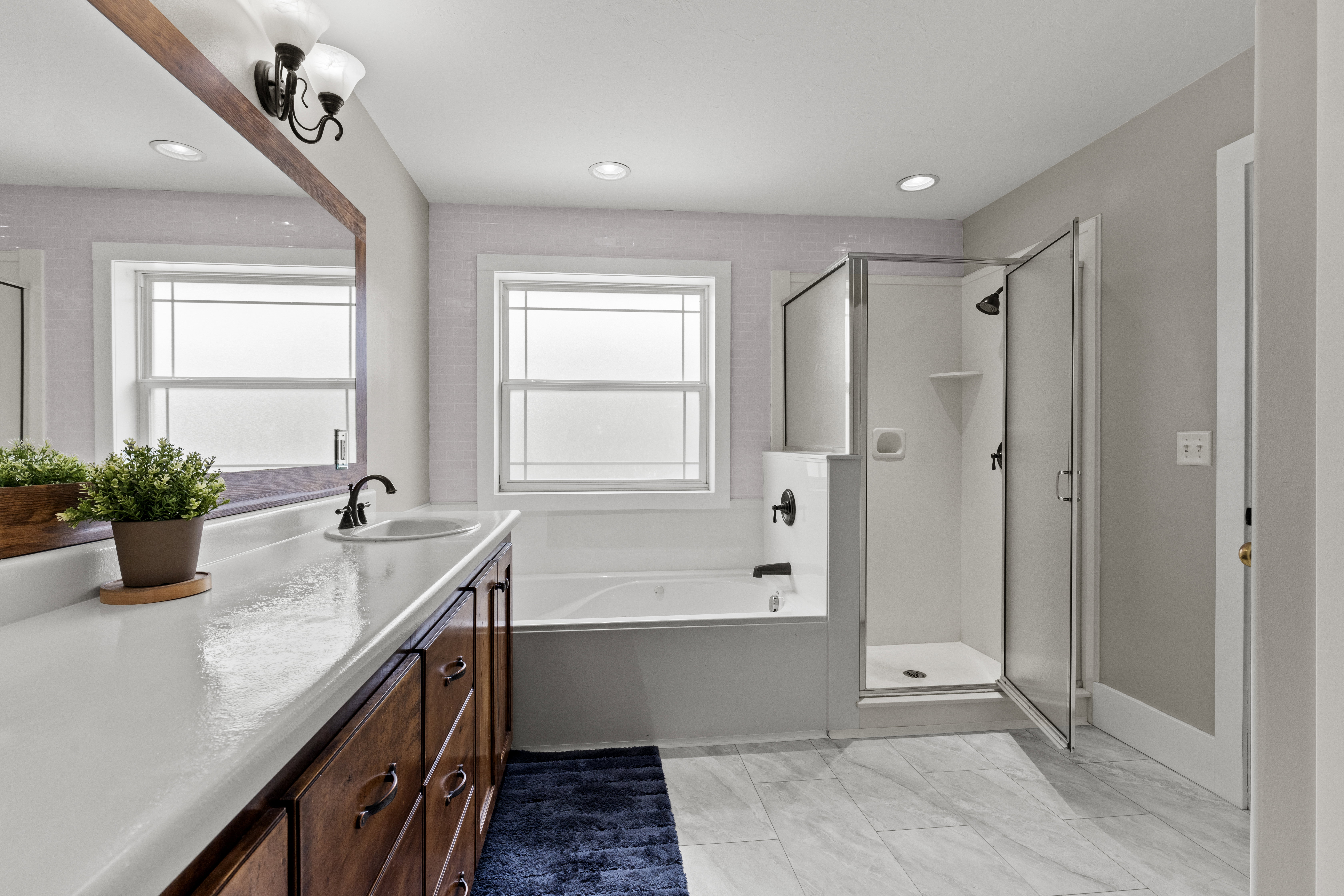 Bathroom featuring a shower stall, a garden tub, vanity, recessed lighting, and light marble finish floors