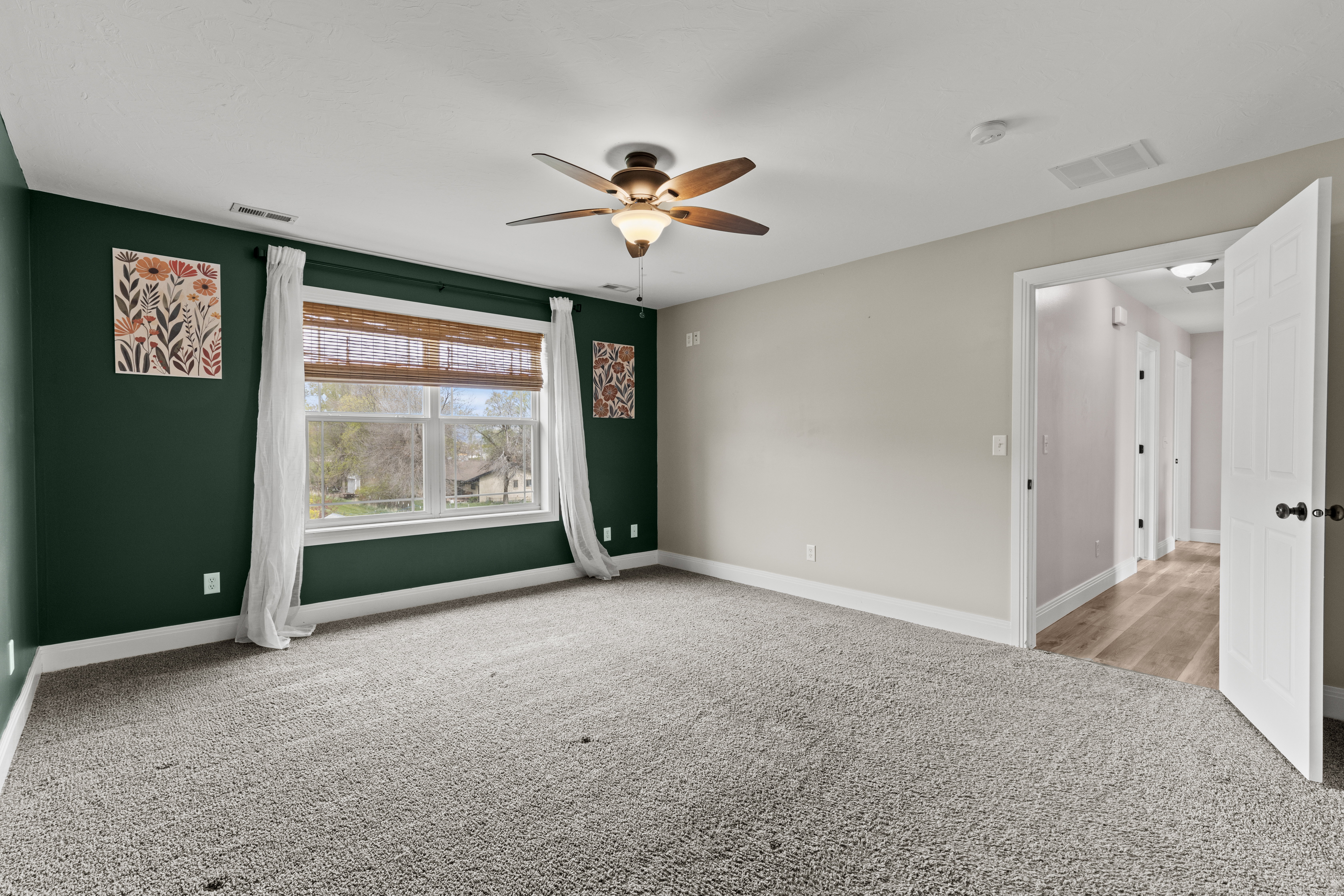 Empty room featuring light carpet and ceiling fan