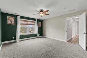 Empty room featuring light carpet and ceiling fan