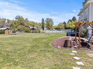 Fenced yard featuring a pergola and a patio area