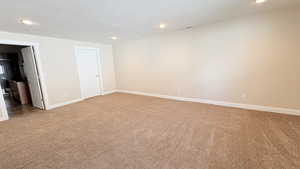 Unfurnished bedroom with light carpet and recessed lighting